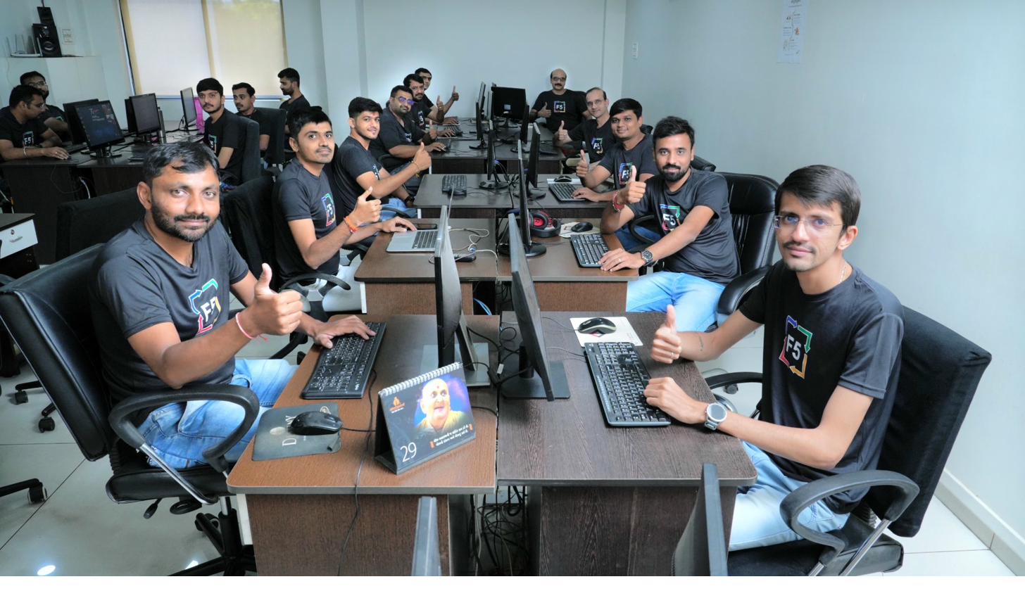 F5 India team members at their workstations giving a thumbs up.