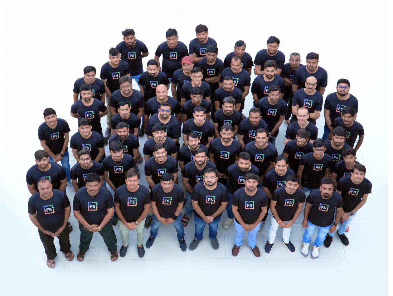 Around sixty F5 team members in branded shirts, photographed from above.